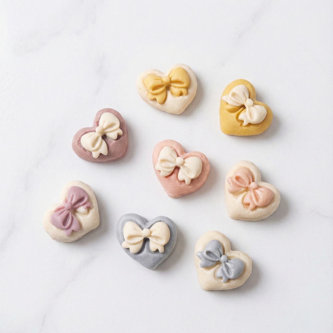 Heart-shaped cookies with bow decorations on a light background